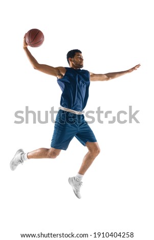 Slam dunk. Young arabian muscular basketball player in action, motion isolated on white background. Concept of sport, movement, energy and dynamic, healthy lifestyle. Training, practicing.