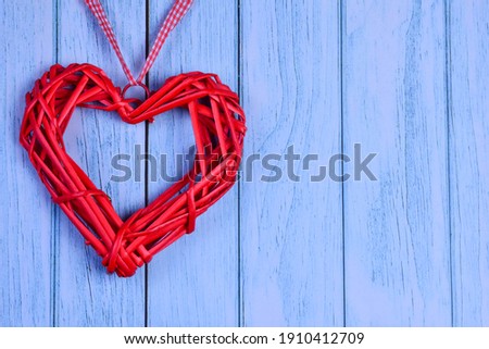 On the background of blue wooden planks on the left side there is a decorative red heart. On the right there is a place for an inscription for Valentine's Day