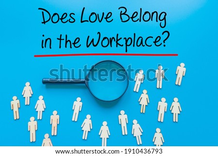 Does Love Belong in the Workplace? Sign on white paper. Man Hand Holding Paper with text. Isolated on Workers concept, Magnifying glass. Blue..   Business concept. Stock Photo