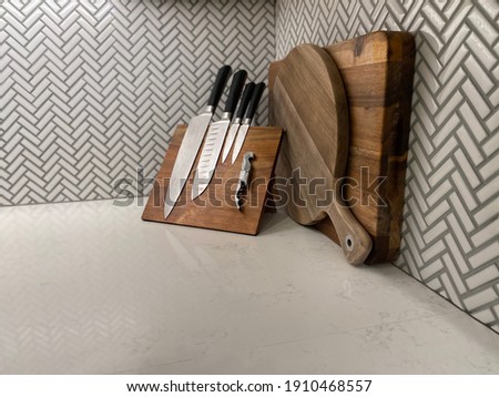 Modern backsplash with touches of rustic style with wooden cutting boards and knives. White on white with splashed of grey and wood are my favorite! 