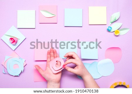 DIY instruction. Step by step guide. The process of making paper flowers from colorful postcard stickers. Little girl preparing a card for mothers day.