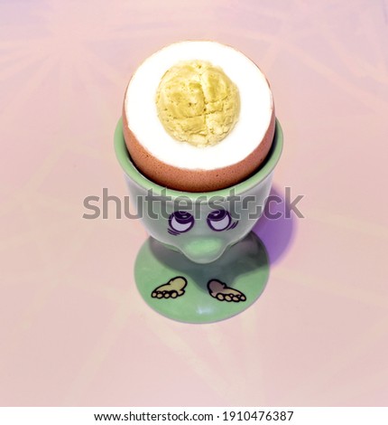 smart egg with a yolk in the form of a brain and in a stand next to a top view