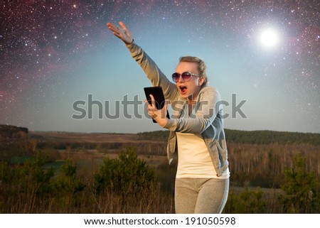 tablet a girl under the stars. Elements of this image furnished by NASA