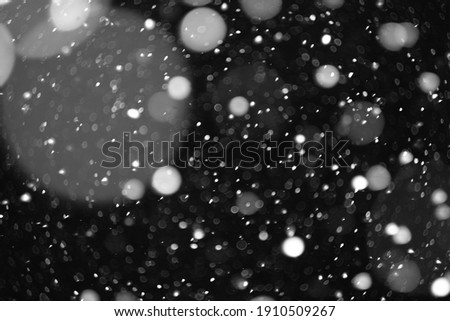 beautiful bokeh from a flying heavy snow on a black background of the night sky
