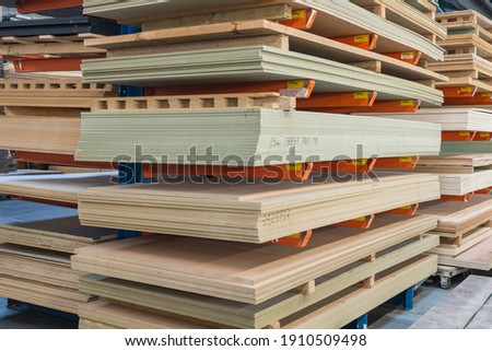 Construction sheet materials stored on cantilever rack in joinery workshop. Royalty-Free Stock Photo #1910509498