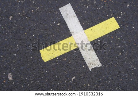 Selective focused photo of cross sign on road surface