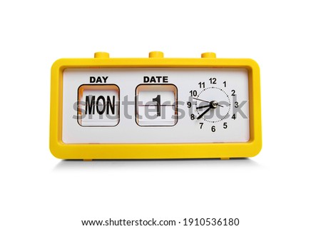 Retro electronic alarm clock and analog flip calendar. Retro design from 60s 70s home interior. Bright yellow color Royalty-Free Stock Photo #1910536180