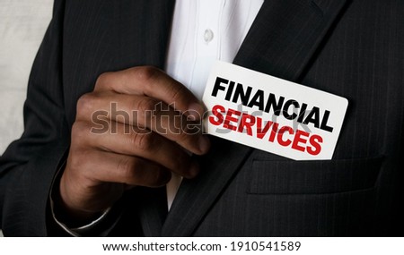 Close up view of a black man holding a business card. A young African businessman takes out a business card from the pocket of his business suit. Business concept and marketing.