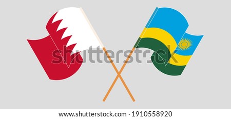Crossed and waving flags of Bahrain and Rwanda