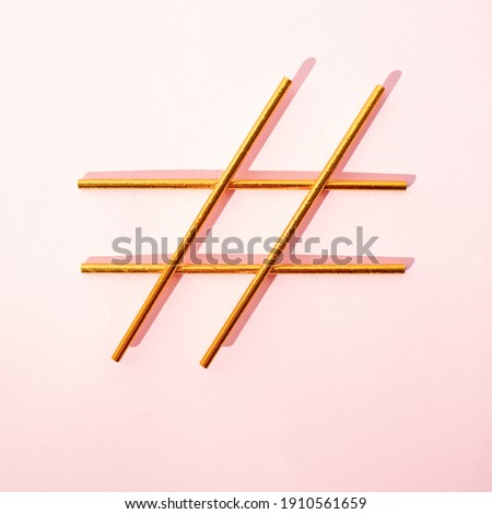 Golden hashtag sign on bright pink background. Creative idea for social media.