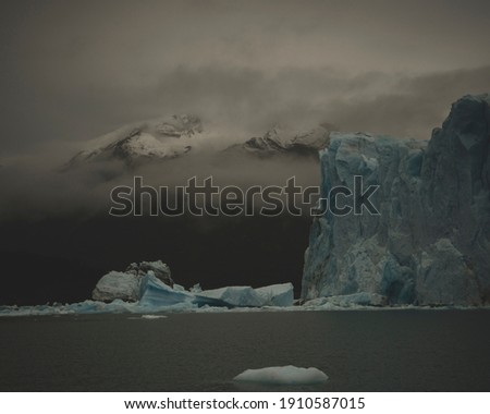 View of the Glacier edge with misty mountain in the background. In Los Glaciares National Park in Argentina.