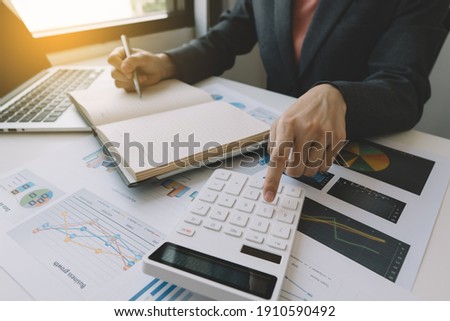 employee accountant man hand press on calculator for make financial report or company's profit monthly at desk , bookkeeper job and work from home concept

