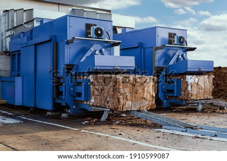 blue paper squeezer container and garabage press machine recycle cardboard to reusable material bales Royalty-Free Stock Photo #1910599087