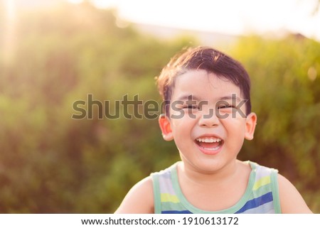 Happy asian boy child showing front teeth with smile and laughing : Healthy happy funny smile face kid.Adorable toddler mixed race kid.portrait asian boy at the park.Summer.pediatric kid clinic. Royalty-Free Stock Photo #1910613172