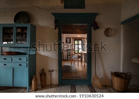 Front view of big old handmade craft mirror in wooden retro picture frame on vintage stucco wall in historic background of traditional country village home interior