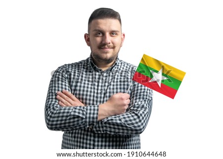 White guy holding a flag of Myanmar smiling confident with crossed arms isolated on a white background.