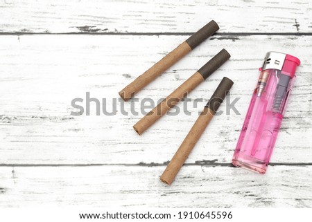 cigarette and lighter on a white grungy wooden table 