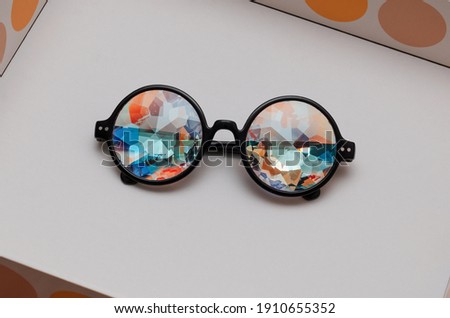 designer glasses with kaleidoscope lenses in box on white background