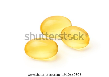 Three golden color oil in soft gel capsule isolated on white background. Clipping path