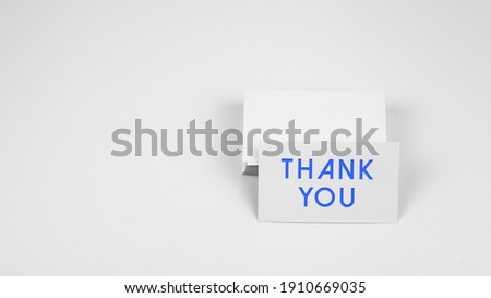 A word Thank You on white paper name card with white background. Concept for presentation