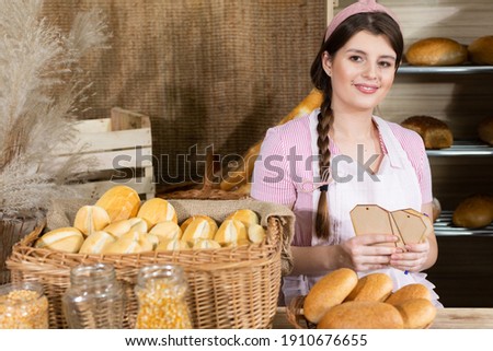 The saleswoman describes the plates for each type of bread. An attractive saleswoman counts the remaining bread for sale.