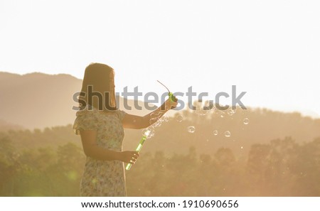 Girl playing with bubbles having fun in nature
