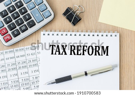 Tax Reform text on notebook on the office table next to a pen and calculator