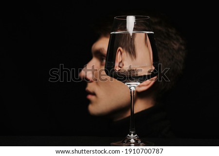 surreal portrait of a man in profile through a glass of water