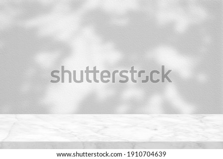 White Marble Table with Dried Leaves Shadow on Concrete Wall Texture Background, Suitable for Product Presentation Backdrop, Display, and Mock up.