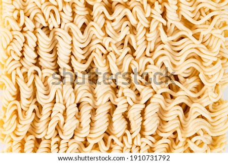 Dry instant noodles in yellow color, close-up. Texture, pattern, background.