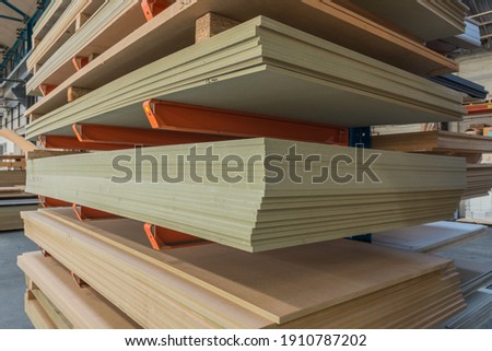 Construction sheet materials stored on cantilever rack in joinery workshop. Royalty-Free Stock Photo #1910787202