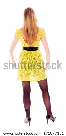 Rear view of a young woman standing with her arms akimbo