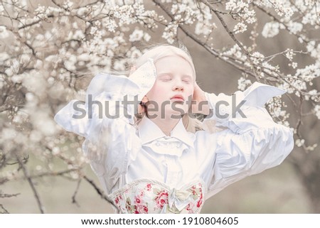 albino girl with a horse albino in a blooming garden