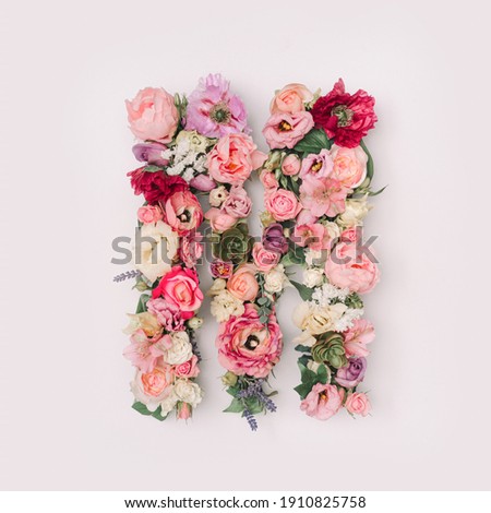 Letter M made of real natural flowers and leaves. Flower font concept. Unique collection of letters and numbers. Spring, summer and valentines creative idea. Royalty-Free Stock Photo #1910825758