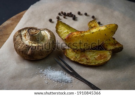 Fried food. Baked mushroom with potatoes on a wooden surface. Unhealthy food.