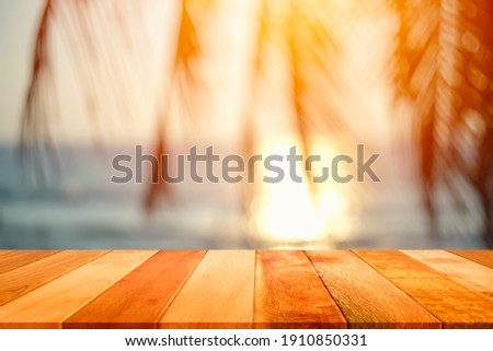 Wood plank with blurred sea and coconut tree background. Concept of beach in summer.