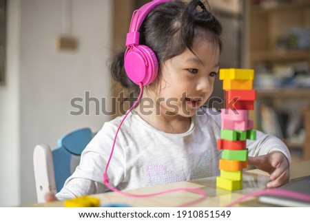 Asian girl learning from headphone and laptop, Happy girl learn online with laptop at home.
