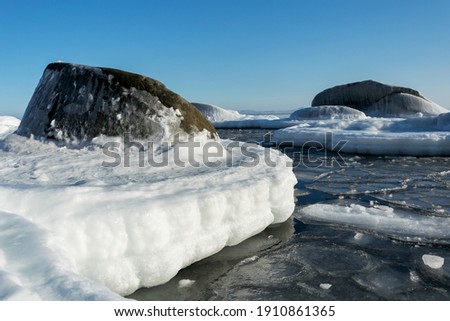 Frozen rocks in the sea on a sunny winter day.