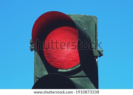 Red traffic light on San Modesto street in Madrid, Spain. Close-up of red traffic light for cars with a blue sky in the background.