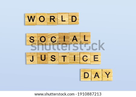 Top view of the word world social justice day laid out from square wooden tiles isolated on blue background. World and international day.