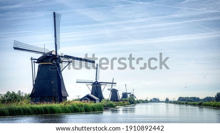 traditional dutch windmills at riverside, landscape picture in the netherlands