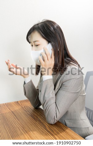 Woman wearing a mask worried about work phone