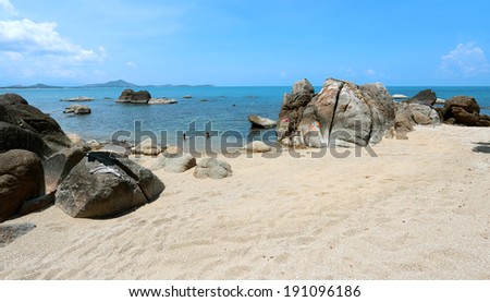 Stones on the beach by the sea on a background of blue sky