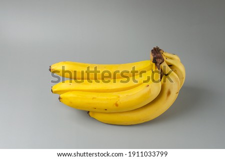 Bunch of bananas on a gray background. Trending color of year 2021 Illuminating and Ultimate gray. Side view minimal still life.