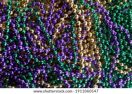 Colorful Mardi gras beads background. Green, purple and gold Merdi gras beads