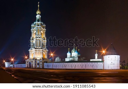 Panoramic view of illuminated Novospassky monastery at night in the center ot Moscow, Russia. An old Orthodox monastery with a white stone wall and a high yellow bell tower in the light of lanterns.