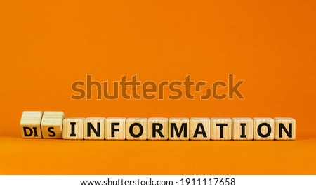 Information or disinformation symbol. Turned cubes and changed words disinformation to information. Orange background, copy space. Business and information or disinformation concept. Royalty-Free Stock Photo #1911117658
