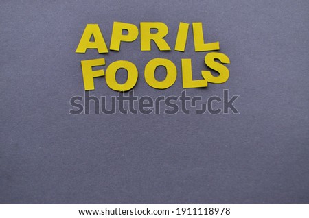Image caption April pranks of yellow paper letters are laid out on a grey background with a copy space. High quality photo