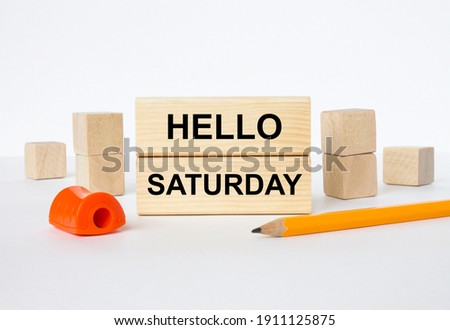 Wooden blocks with text Hello Saturday with sharpener and pencil. Concept photo