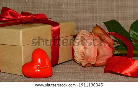 Gift box with red bow, pink rose and aroma candle white shape of heart